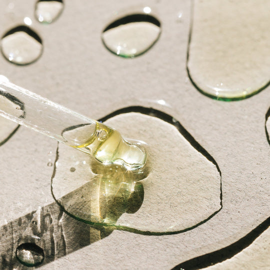 Close-up of a dropper with liquid on a textured surface